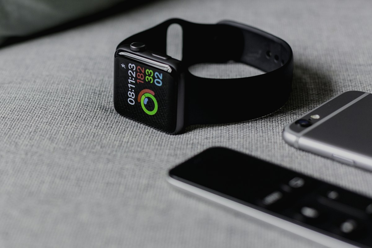 Smartphone, smartwatch and headphones arranged on a desk