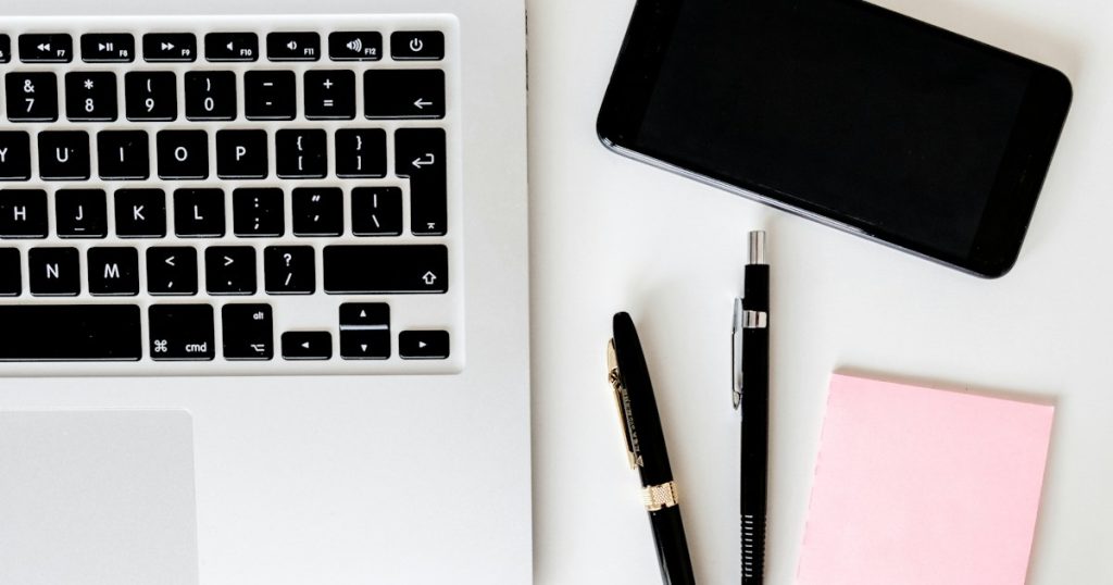 Laptop, smartphone and electronics arranged on a modern work desk