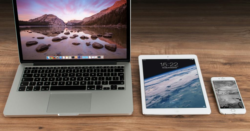 Laptop, tablet and smartphone arranged together on a workspace