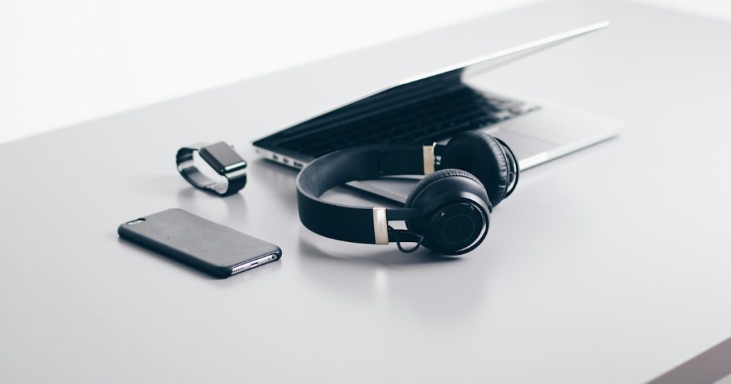Laptop, smartphone and electronics accessories arranged on a desk